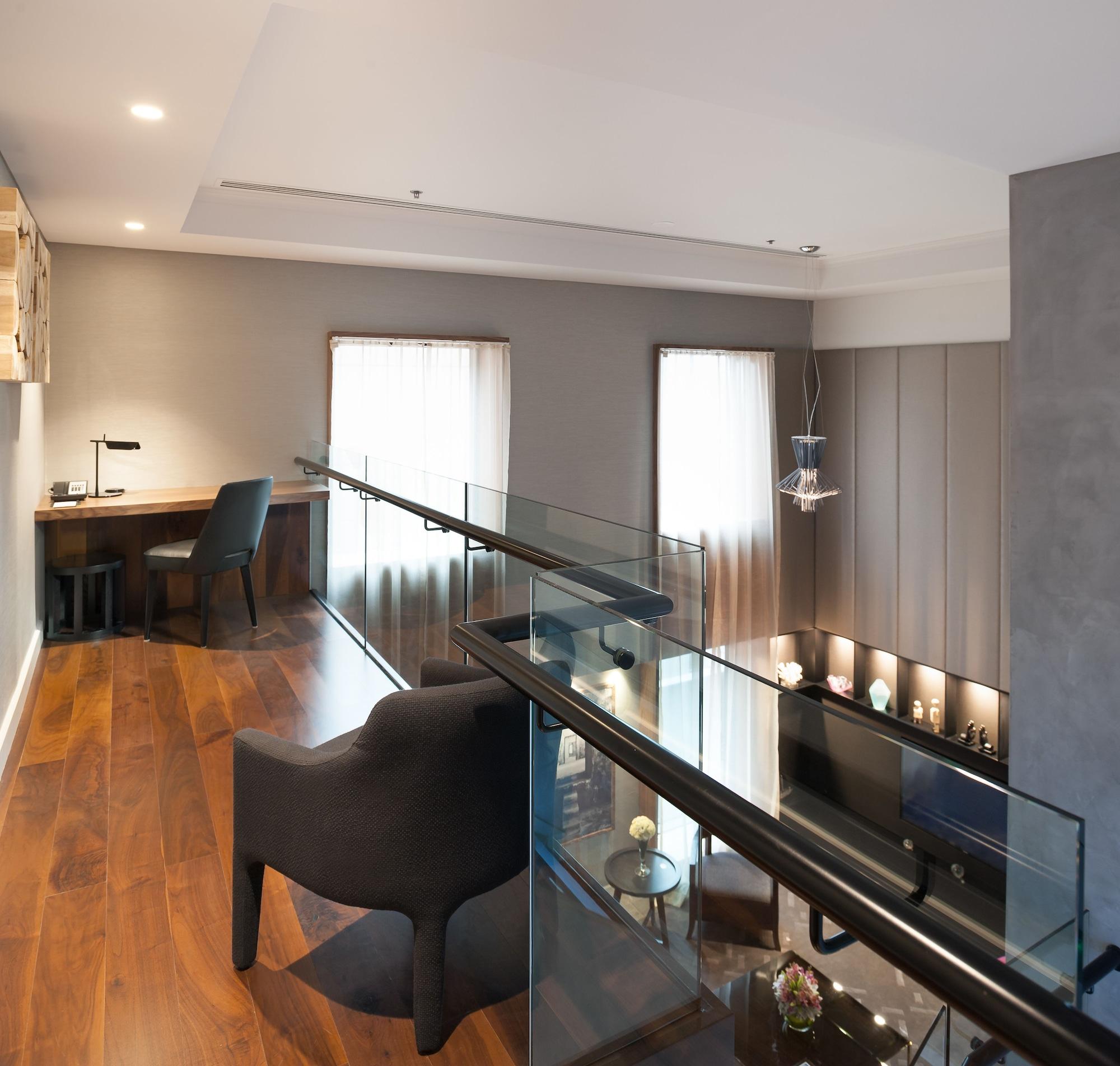 Hotel Stamford Plaza Melburne Exterior foto The photo shows a modern interior space, featuring a second-floor balcony overlooking a lower level. The decor is stylish and minimalistic, with a combination of wooden flooring and neutral-colored walls. 

On the upper level, there is a small desk a