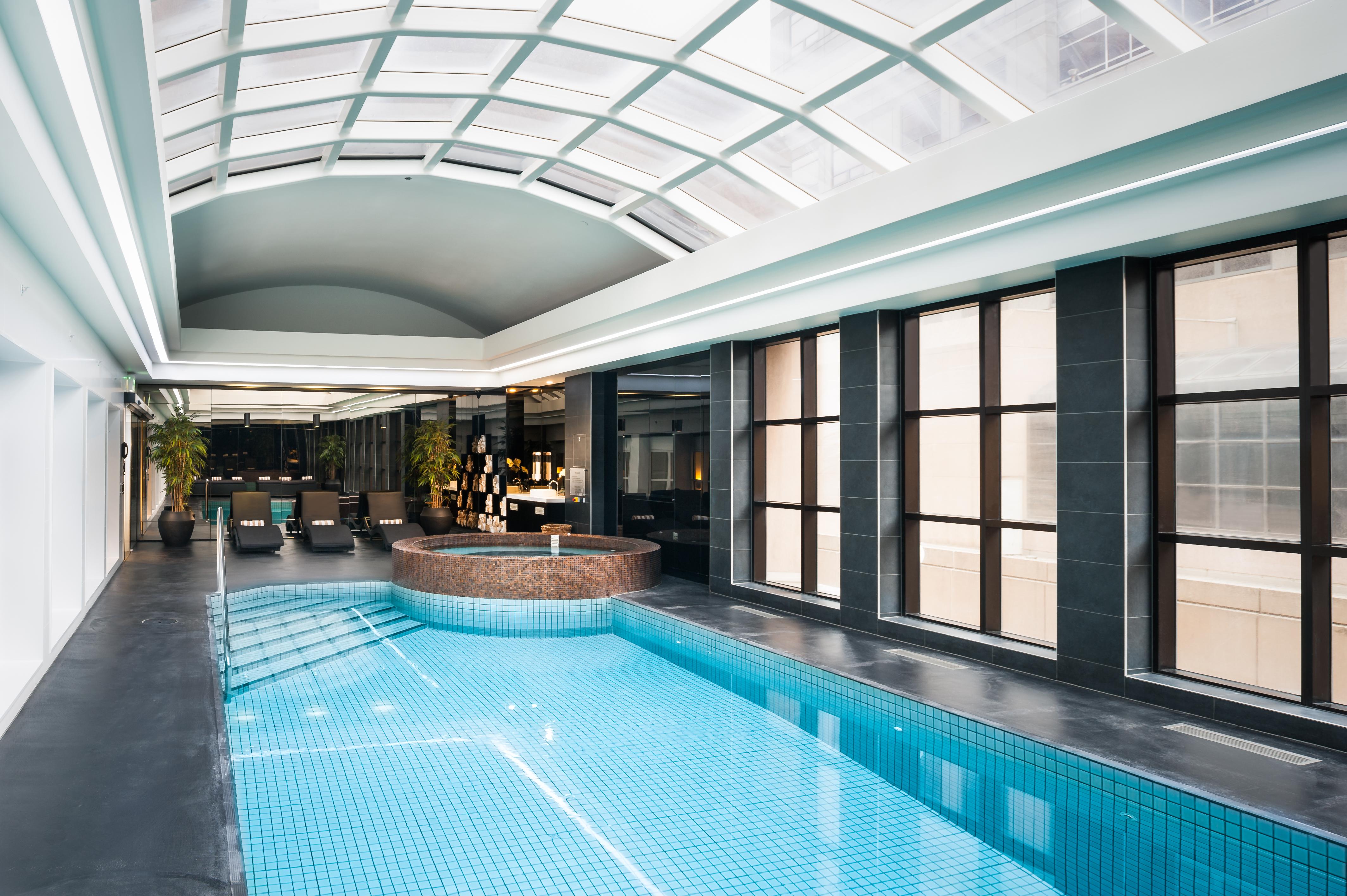 Hotel Stamford Plaza Melburne Exterior foto The photo shows an indoor swimming pool area with a modern and sleek design. The pool is rectangular and features bright blue tiles. Above the pool, there's a large, transparent glass ceiling that allows natural light to flood the space. Surrounding 
