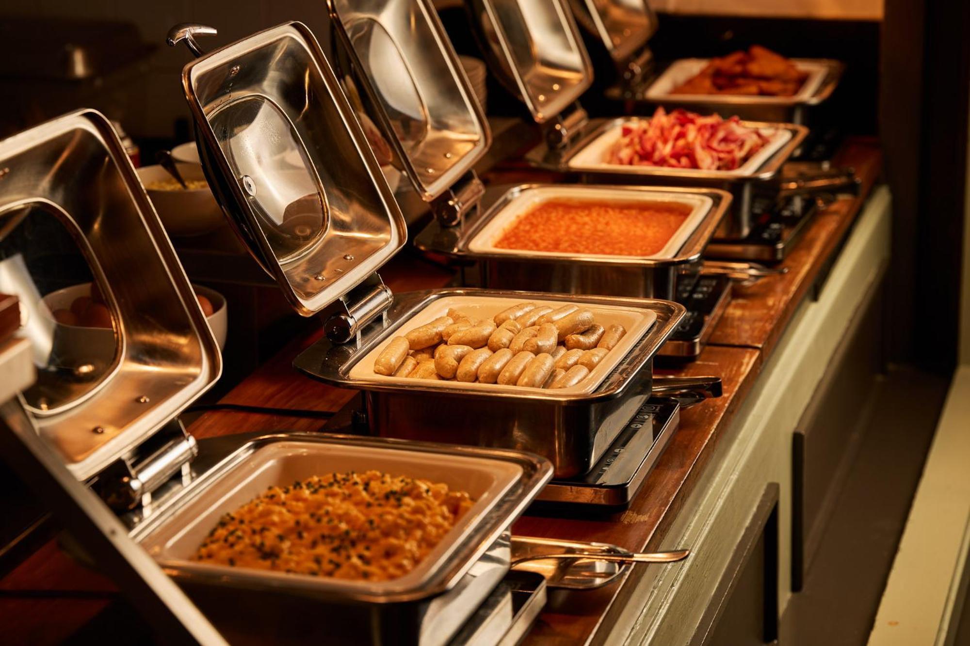 Hotel Stamford Plaza Melburne Exterior foto The photo depicts a buffet setup featuring multiple food trays in stainless steel chafing dishes. Each dish is opened to display different types of food. The dishes contain a variety of items, which might include a mix of proteins, vegetables, or sta