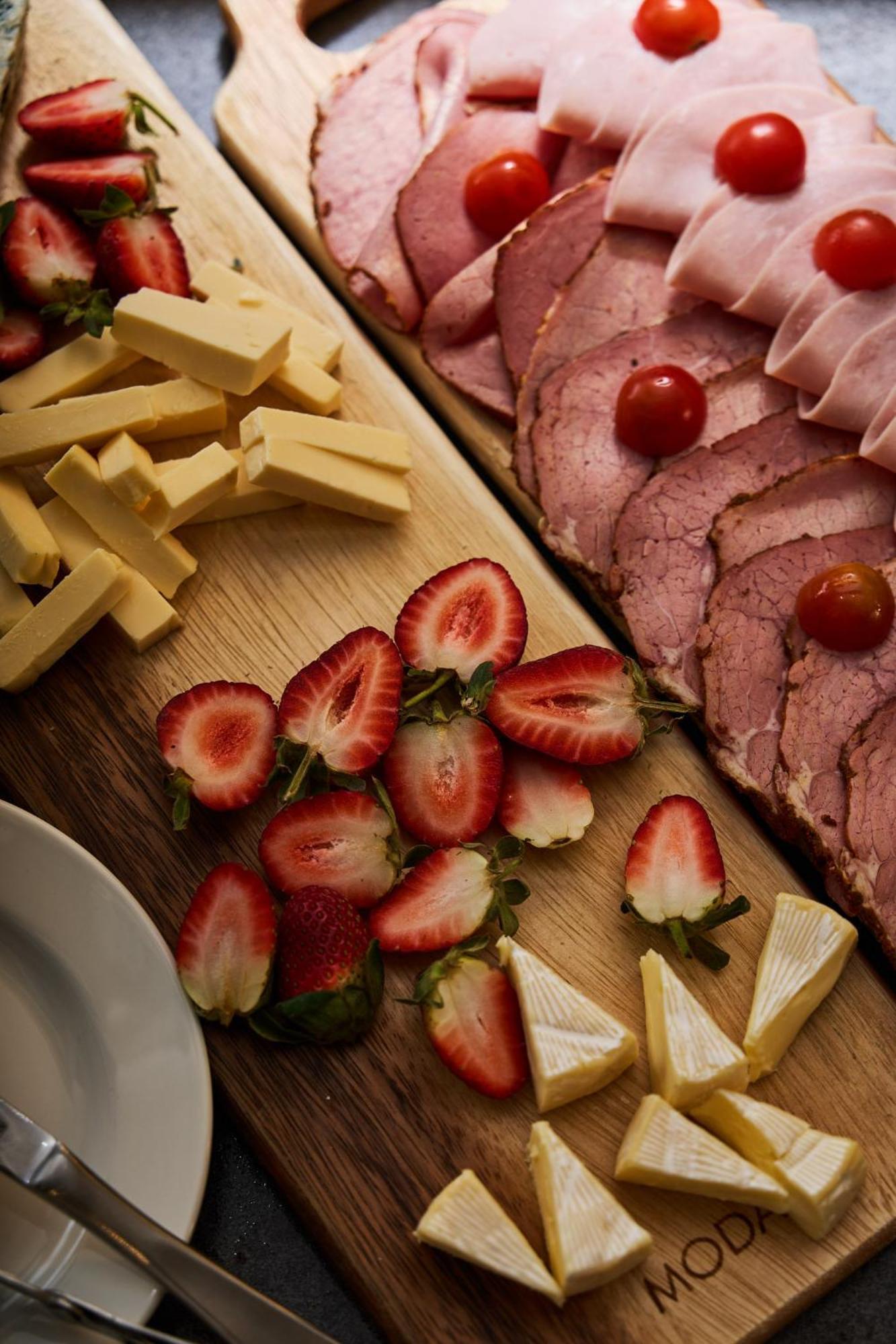 Hotel Stamford Plaza Melburne Exterior foto The photo displays an assortment of food items arranged on a wooden surface. There are slices of various meats, including ham, alongside round cherry tomatoes. Next to the meat, there are several pieces of yellow cheese cut into sticks. Additionally,