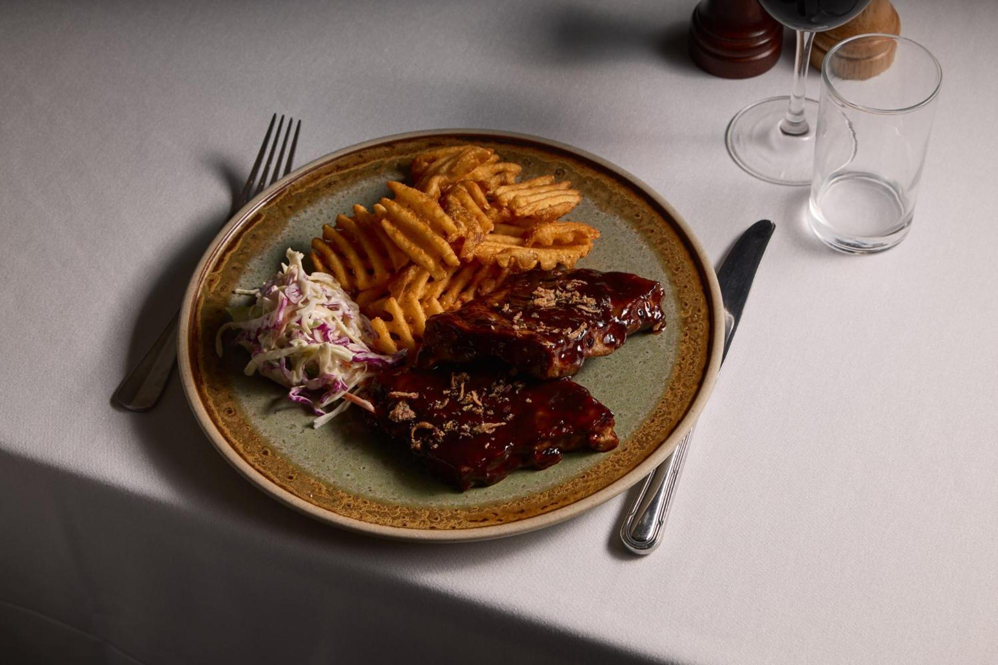Hotel Stamford Plaza Melburne Exterior foto The photo displays a plate of food featuring two pieces of steak that appear to be glazed with a rich sauce. Alongside the steak, there are crinkle-cut fries arranged neatly on one side of the plate. Additionally, there's a small serving of coleslaw,