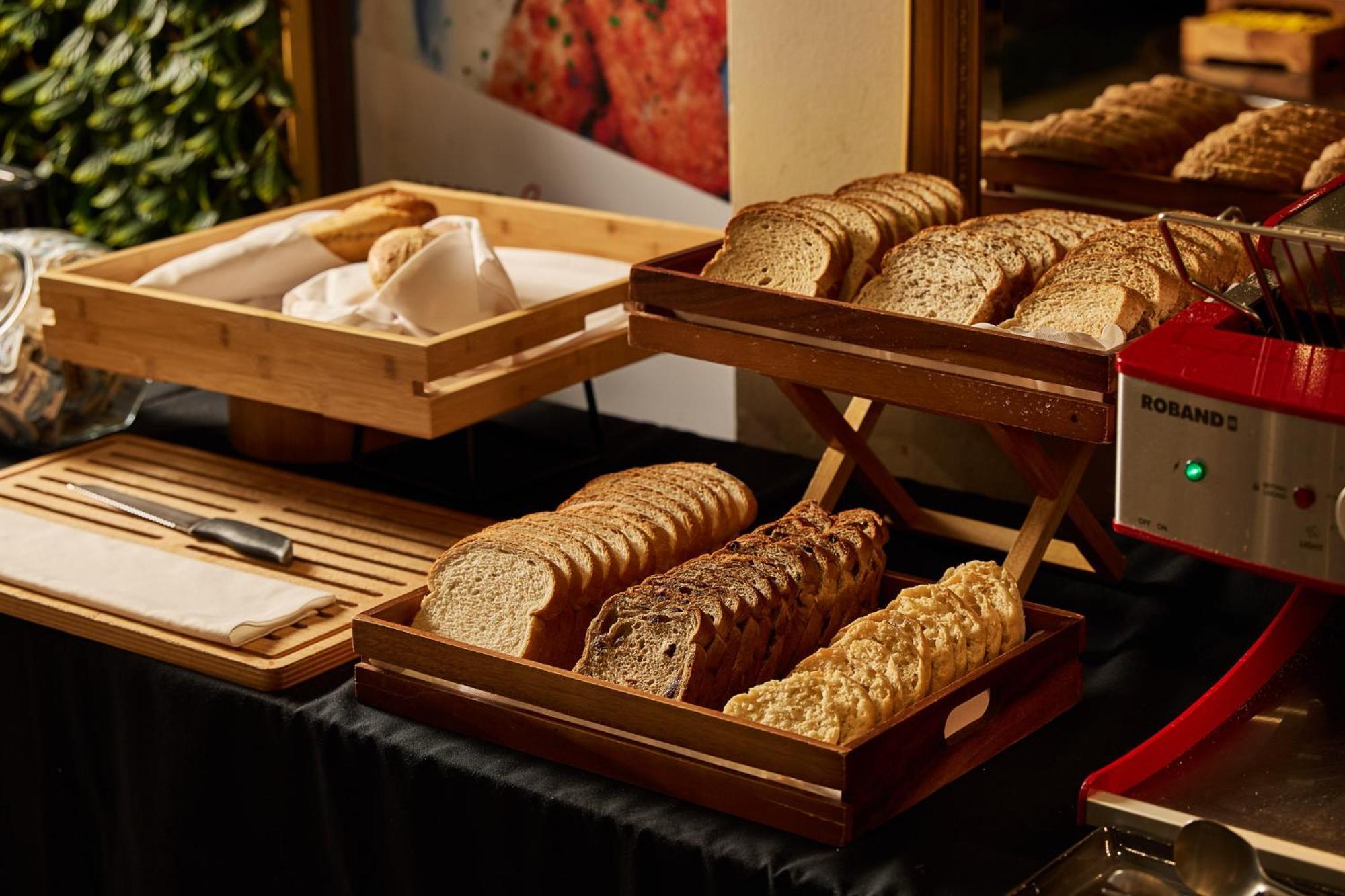 Hotel Stamford Plaza Melburne Exterior foto The photo shows a display of various types of bread arranged on wooden trays. There are several stacks of sliced bread, including light and dark varieties. One tray appears to hold a selection of whole grain or multigrain bread, while another feature