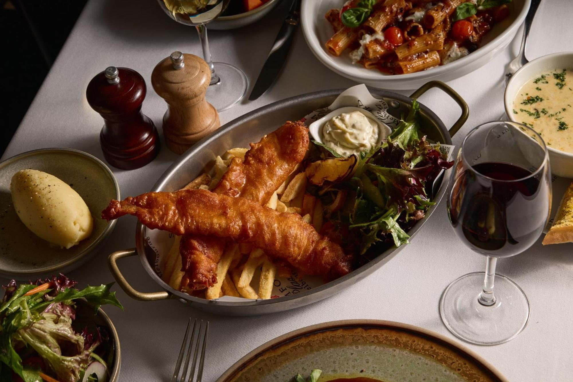 Hotel Stamford Plaza Melburne Exterior foto The photo showcases a beautifully arranged meal. In the foreground, there are two pieces of golden-battered fish served with crispy fries. Accompanying the fish is a small dollop of creamy sauce and a side salad, which has a mix of greens. Surroundin